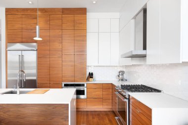 Şikago, IL, ABD - 1 Kasım 2020: Ahşap ve beyaz dolapları, beyaz şelale granit adası, KitchenAid cihazları ve beyaz beşgen döşeme döşemeleri olan modern, yenilenmiş bir mutfak.