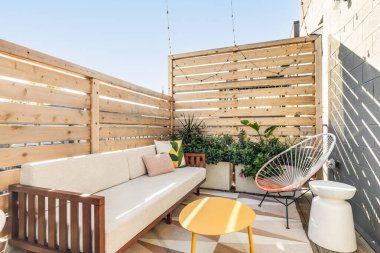 Chicago, IL, ABD - 5 Kasım 2020: ahşap bir çitle çevrili bir apartman dairesinde küçük bir açık hava terası. Verandada rahat mobilyalar ve boş yerleri dolduracak bitkiler var..
