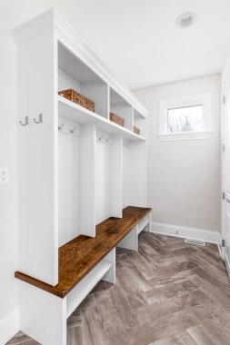Şikago, IL, ABD - 12 Ekim 2020: Herringbone döşemeleri, beyaz bir palto askısı ve ahşap bankı olan modern bir çiftlik evi antresi veya çamur odası.