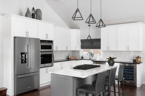 ELMHURST, IL, ABD - 12 HAZİRAN 2021: Modern bir çiftlik evinde güzel beyaz bir mutfak, adanın tavanından sarkan siyah ışıklar, bar tabureleri ve KitchenAid çelik aletleri.