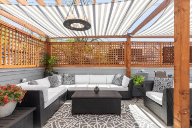 Chicago, IL, ABD - 4 AĞUSTOS 2021: Üstü pergola kaplı rahat bir çatı terası, dış mobilyalar, ve güneş içinden geçiyor.
