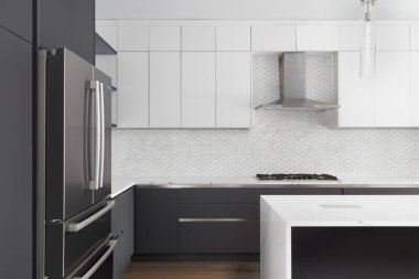 Şikago, IL, ABD - 12 Ekim 2020: Bosch paslanmaz çelik aletleri, bir şelale granit adası, cam kolye ışıkları ve ahşap döşemeli modern, beyaz ve gri bir mutfak.