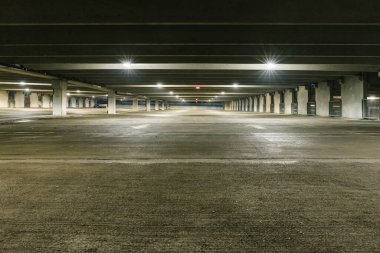 Grungy, loş ışıklı boş Park garaj ile genel gider ışık ve tavanda asılı bir çıkış işareti.