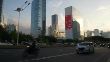 JAKARTA, INDONEZYA - CRCA 2020: Güneşli bir gün Jakarta kenti yoğun trafik caddesi kavşağı, 4k Endonezya