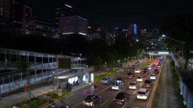 JAKARTA, INDONESIA - CIRCA 2020: Jakarta şehri gece vakti ünlü kalabalık trafik sokağı, panorama 4k Endonezya 'yı aydınlattı