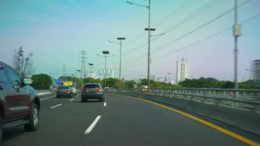 JAKARTA, INDONEZYA - CRCA 2020: Güneşli bir gün Jakarta kenti yoğun trafik caddesi kavşağı, 4k Endonezya