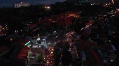 BALI, INDONESIA - CIRCA 2020: Gece aydınlatılmış bali adası, ünlü işlek cadde kavşağı havası panorama 4k Endonezya