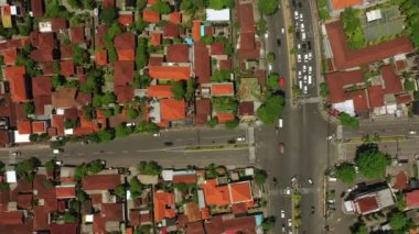 Şehir trafiği kavşağında güneşli bir gün olan Bali Adası uçuşu, gökyüzü tepeden aşağı panorama, 4K Endonezya