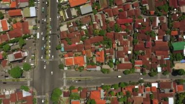 Şehir trafiği kavşağında güneşli bir gün olan Bali Adası uçuşu, gökyüzü tepeden aşağı panorama, 4K Endonezya