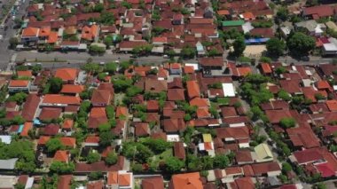 Şehir trafiği kavşağında güneşli bir gün olan Bali Adası uçuşu, gökyüzü tepeden aşağı panorama, 4K Endonezya