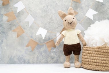 knitted hare with a knitted basket and flags on the wall