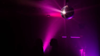 Disko topuyla parti atmosferi. Disko topundan yansıyan ışık demetleri.