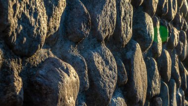 Gri ezilmiş taşlar ve güneş ışığıyla gerçek bir arka plan. Yaz günlerinde eski tuğla duvar. Soyut dekoratif arkaplan ya da sanat dokusu. Boşluğu kopyala.
