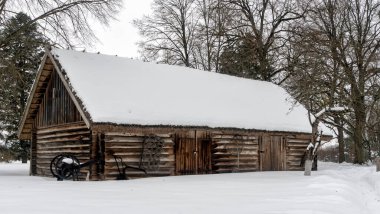 Güzel bir kış doğası geçmişi. Eski bir ahırı olan kırsal bir yer. Kışın karla kaplı çatıdaki ahır. Doğa konsepti.