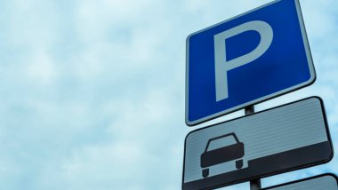 Mavi yol işareti, üzerinde P harfi olan dikdörtgen levha mavi gökyüzüne karşı izole edilmiş. Bulutlu mavi bir arka planda park sembolü. Metin için boşluk.