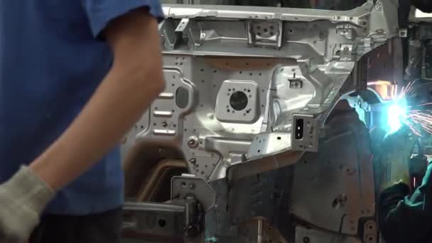 汽车制造厂在车体上焊接工人 从焊接汽车配件喷出的火花 工厂里的现代汽车总成 工业概念 — 图库视频影像