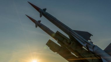 Two combat missiles aimed at the sky. Old ballistic missile launcher on blue sky background. Antiaircraft forces, military industry. Space for text. clipart