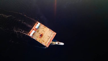 Küçük ahşap feribotun turuncu arabalı havadan görüntüsü. Suda geleneksel feribot. Seyahat ve macera konsepti.