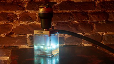 Tahta masadaki nargile kare matarası. Orijinal kare tasarımcı nargile.