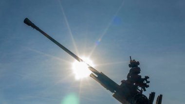 Gün batımında mavi gökyüzü ve güneşin arka planına karşı uçaksavar bataryalarının bir parçası. Metin için boşluk.