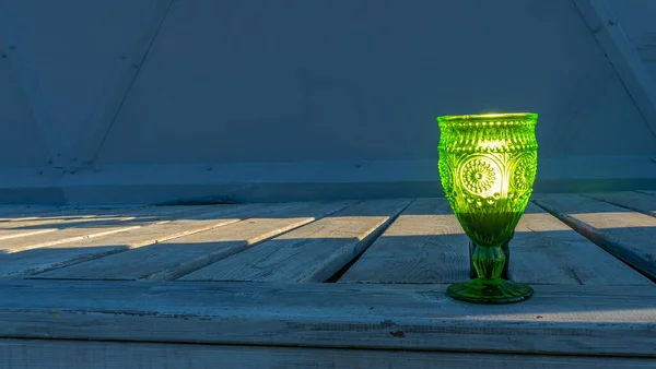 Copos Vazios Iluminados Vidro Verde Uma Haste Fundo Madeira Vista — Fotografia de Stock