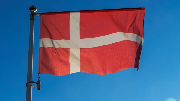 丹麦国旗在蓝天上闪烁着太阳光和透镜的光芒 外交概念 国际关系 案文的篇幅 — 图库照片