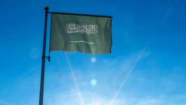 Suudi Arabistan bayrağı güneş ışınlarıyla mavi gökyüzüne karşı. Diplomasi konsepti. Uluslararası ilişkiler. Metin için boşluk.
