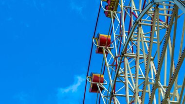 Kulübeli dönme dolap. Lunaparkta mavi gökyüzüne karşı atlıkarınca. Tatil kavramı.