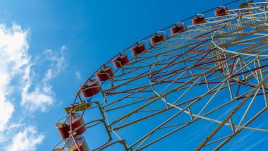 Kulübeli dönme dolap. Lunaparkta mavi gökyüzüne karşı atlıkarınca. Tatil kavramı.