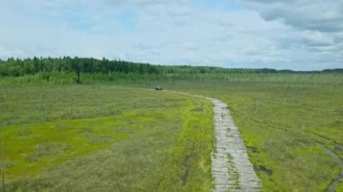 Alçak basınçlı tekerlekleri ve ulaşılması zor lastikleri olan özel bir off-road arabası. Her yere yayılmış bir araç. Dramatik gökyüzü arka planında bataklık için ekolojik taşıma.