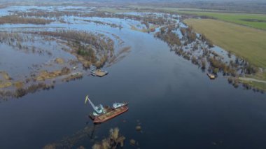 Dredger nehirdeki çim alanını derinleştirmeye çalışıyor. Nehirdeki bir tarakçı tarafından temizleniyor ve derinleşiyor. Nehirde gün batımı. Endüstriyel kavram.