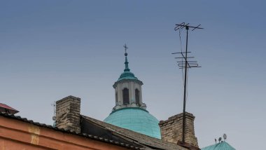 Televizyon antenleri ve apartman çatılarından çapraz görüşlü Katolik alemi. Tapma ve teknoloji konsepti.