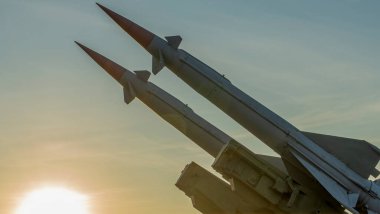 Two combat missiles aimed at the sky. Old ballistic missile launcher on blue sky background. Antiaircraft forces, military industry. Space for text. clipart