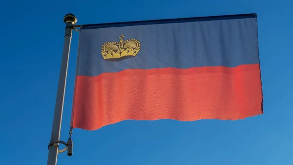 Lichtenštejnská Národní Vlajka Vlajkovém Stožáru Před Modrou Oblohou Slunečními Paprsky — Stock fotografie