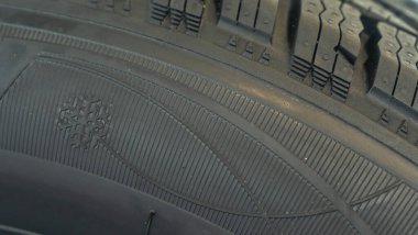Dükkandaki yeni lastiğin kış basamaklarının yakın görüntüsü. Kar yolu için otomobil lastiği. Seçici odaklanma. Dükkanda lastik satışı. Güvenlik kavramı.