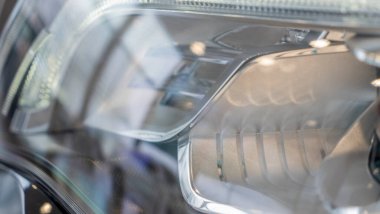 Yeni arabanın far yansıtıcısının yakın çekim elementi. Hafif odaklı araba arka planı. Yeni arabaların farları. LED farlarından birinin detaylarını kapat. Modern siyah araba..