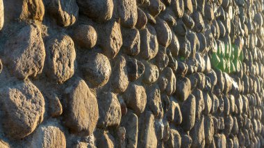 Gri ezilmiş taşlar ve güneş ışığıyla gerçek bir arka plan. Yaz günlerinde eski tuğla duvar. Soyut dekoratif arkaplan veya sanat dokusu.