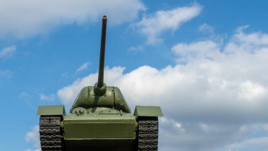 Tank T 34 mavi gökyüzüne karşı podyumda duruyor. Efsanevi zafer tankının 2. Dünya Savaşı anıtı. Metin için boşluk.