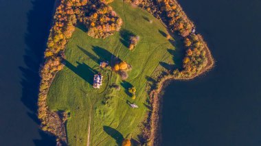 Çatıda çim ve adada çan kulesi olan eski harabe bir kilise. Eski kilise kalıntılarının havadan görünüşü. Tarihi kavramlar.