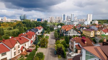 Önde yeni bir mahalle köy panoramik görünümü ve arka planda Belarus ulusal kütüphanesinin modern binası.