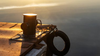 Arkasında günbatımı nehri olan köstebeğin üzerine demirle..