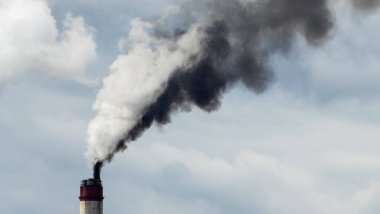 Gökyüzü arka planında bacadan çıkan endüstriyel duman. Kömür santralinden çıkan gri dumanlı yüksek baca borularının görüntüsü. Fosil yakıtlı elektrik üretimi. Rüzgâr kirliliği.