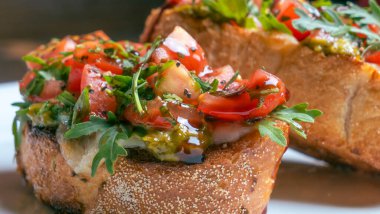 Beyaz arkaplanda domates ve mozzarella bruschetta 'nın yakın plan görüntüsü.