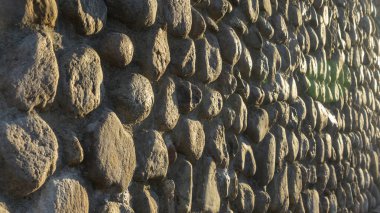 Gri ezilmiş taşlar ve güneş ışığıyla gerçek bir arka plan. Yaz günlerinde eski tuğla duvar. Soyut dekoratif arkaplan veya sanat dokusu.