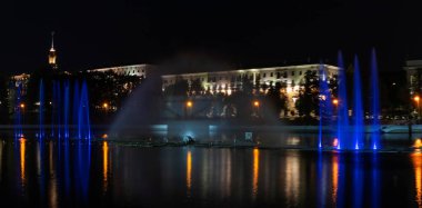 Geceleyin bir nehirde çok renkli bir müzik çeşmesi. Aydınlanmadan kaynaklanan gece çeşmesi. Mesaj için yer var. Kutlama konsepti.