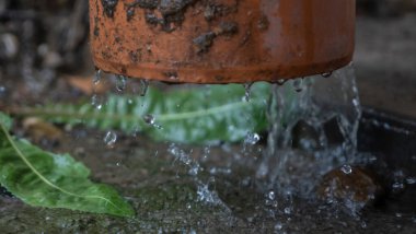 Şiddetli yağmur. Yağmur suyu çatıdan drenaj borusuna akıyor..