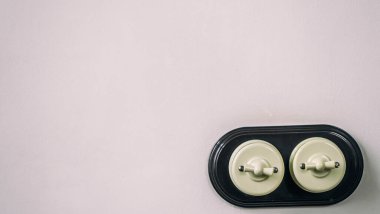 Boş beton bir duvara eski moda elektrik kabloları monte edilir. İki eski şalterli elektrik şalteri. Kopyalanacak boşluklu enerji ve elektrik teması.