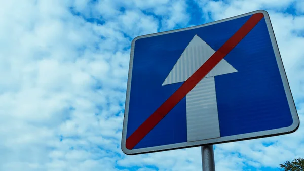 Синій Дорожній Знак Закінчується Одну Сторону Трафіком Незграбному Фоні Блакитного — стокове фото