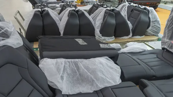 Depodaki koltuklar paketin içinde. Araba koltuğu montaj hattı çalışıyor. Endüstri kavramı.