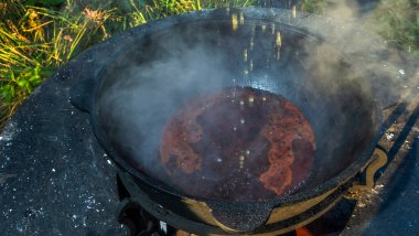 Büyük bir kazanda şarap kaynattım. Sıcak şarap büyük bir tencerede pişirilir. Geleneksel festivalde vitaminler. Çeşitli meyve ve baharatlarla sıcak şarap.